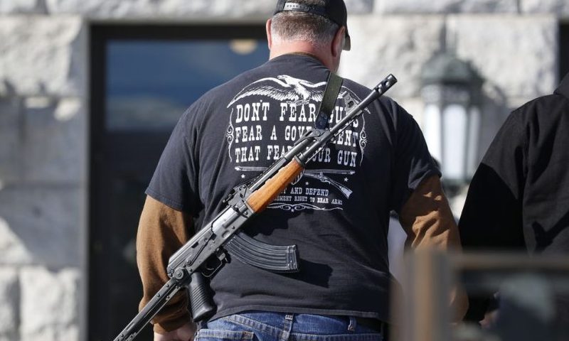 FILE - A man carries his weapon during a second amendment gun rally at Utah State Capitol on Feb. 8, 2020, in Salt Lake City. Utah is one of several more states weighing proposals this year that would allow people to carry concealed guns without having to get a permit, a trend supporters say bolsters Second Amendment rights but is alarming to gun-control advocates. (AP Photo/Rick Bowmer, File)