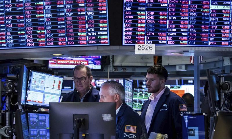 In this photo provided by the New York Stock Exchange, a trio of specialists work at a post on the floor, Monday, June 13, 2022. (Courtney Crow/New York Stock Exchange via AP)
