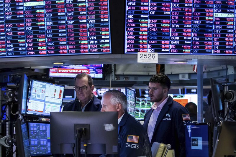 In this photo provided by the New York Stock Exchange, a trio of specialists work at a post on the floor, Monday, June 13, 2022. (Courtney Crow/New York Stock Exchange via AP)