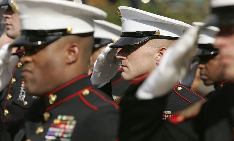 SAN FRANCISCO - NOVEMBER 10: Members of the U.S. Marine Corp honor guard salute during the singing of the National Anthem during the unveiling ceremony for the new "Distinguished Marines" commemorative stamps November 10, 2005 in San Francisco, California. The U.S. Postal Service issued a commemorative stamp series called "Distinguished Marines." on the 230th birthday of the U.S. Marine Corp. The four-stamp series features images of U.S. Marines Lewis B. Puller, Daniel J. Daly, John Basilone and John A. Lejeune. (Photo by Justin Sullivan/Getty Images)