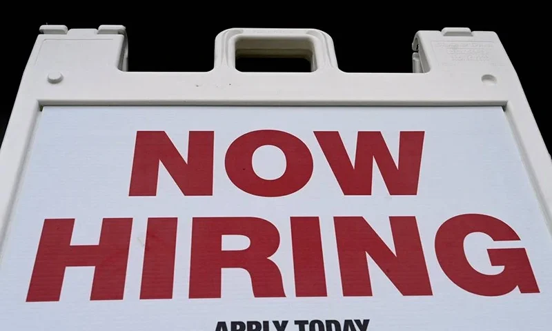 A "Now Hiring" sign is displayed in front of a store on January 13, 2022 in Arlington, Virginia. (Photo by OLIVIER DOULIERY / AFP) (Photo by OLIVIER DOULIERY/AFP via Getty Images)