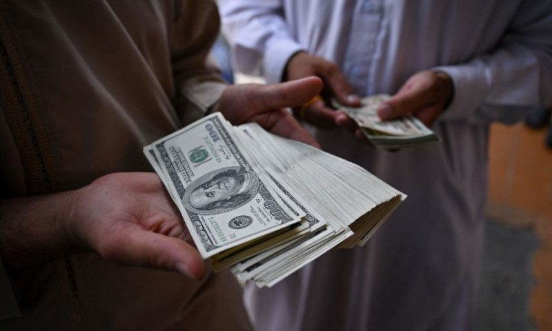 Currency traders show stacks of US dollars at the currency exchange centre in Herat city on August 4, 2022. (Photo by Lillian SUWANRUMPHA / AFP) (Photo by LILLIAN SUWANRUMPHA/AFP via Getty Images)