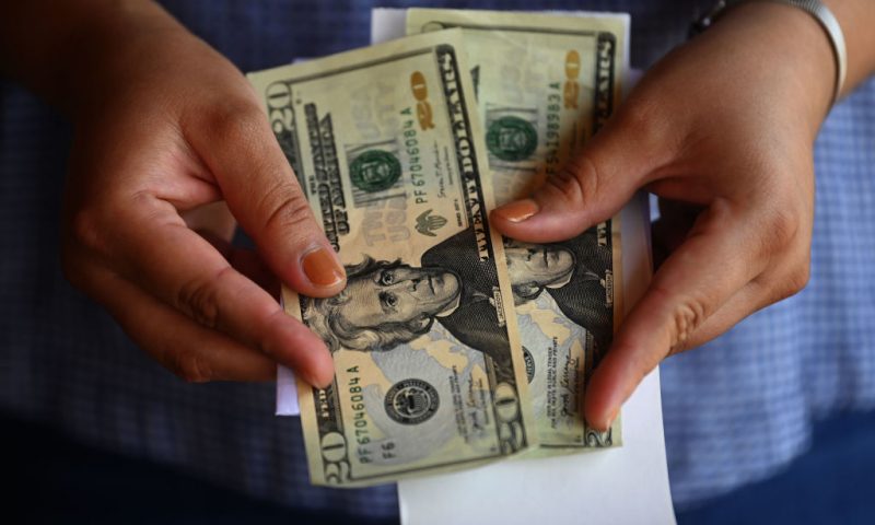 A woman counts money outside a U.S. remittance collection agency in San Isidro, 70 km northeast of San Salvador, on June 10, 2020, amid the new coronavirus pandemic. - The drop of remittances, which represents the 16% of the gross domestic product (GDP) of El Salvador, is attributed to the loss of jobs in the US due to the COVID-19 pandemic. GUatemala and Honduras have also seen their incomes reduced. (Photo by MARVIN RECINOS / AFP) (Photo by MARVIN RECINOS/AFP via Getty Images)