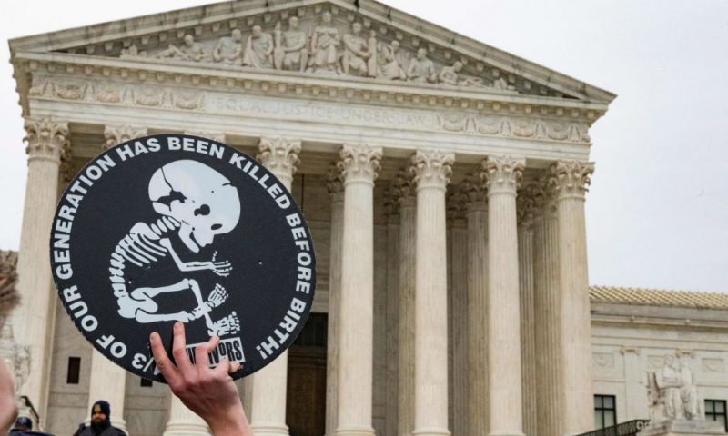 An anti-abortion activist holds up a sign in front of the US Supreme Court building as as pro- and anti-abortion demonstrators protested in front of the US Supreme Court Building in Washington, DC, on January 22, 2023, the 50th anniversary of Roe v. Wade, the landmark court decision that was overturned by the US Supreme Court in June, eliminating the constitutional right to abortion. - The Court on June 24, 2022, struck down the Roe v. Wade decision which legalized abortion, ending five decades of constitutional protections. (Photo by ROBERTO SCHMIDT / AFP) (Photo by ROBERTO SCHMIDT/AFP via Getty Images)