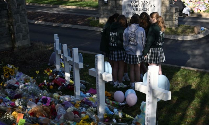 Peopel gather at a makeshift memorial for victims of a shooting at the Covenant School campus, in Nashville, Tennessee, March 29, 2023. - A heavily armed former student killed three young children and three staff in what appeared to be a carefully planned attack at a private elementary school in Nashville on March 27, 2023, before being shot dead by police. Chief of Police John Drake named the suspect as Audrey Hale, 28, who the officer later said identified as transgender. (Photo by Brendan SMIALOWSKI / AFP) (Photo by BRENDAN SMIALOWSKI/AFP via Getty Images)