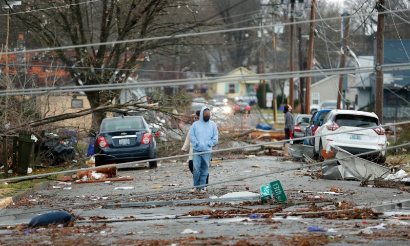 Bowling Green, Kentucky, residents look at the damage following a tornado that struck the area on December 11, 2021. - Tornadoes ripped through five US states overnight, leaving more than 70 people dead Saturday in Kentucky and causing multiple fatalities at an Amazon warehouse in Illinois that suffered "catastrophic damage" with around 100 people trapped inside. The western Kentucky town of Mayfield was "ground zero" of the storm -- a scene of "massive devastation," one official said. (Photo by Gunnar Word / AFP) (Photo by GUNNAR WORD/AFP via Getty Images)