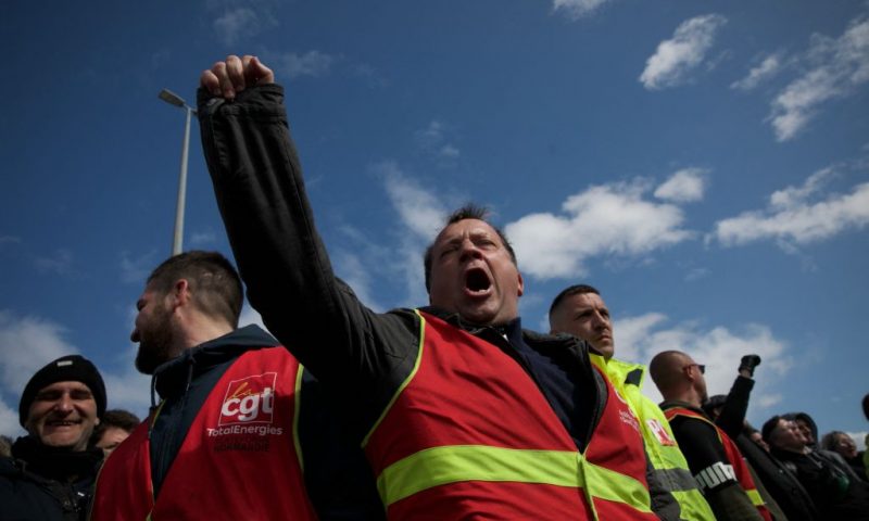 Totalenergies striking employees demonstrate outside Gronfreville-l'Orcher refinery on March 24, 2023, a week after the government pushed a pensions reform through parliament without a vote, using the article 49.3 of the constitution. - Protesters clashed with French security forces Thursday in the most serious violence yet of a three-month revolt against President Emmanuel Macron's hugely controversial pension reform. Almost 150 police were injured and scores of protesters arrested nationwide, the government said, as a day of protests descended into chaos in several cities including Paris, where protesters lit fires in the historic centre of the city. (Photo by LOU BENOIST / AFP) (Photo by LOU BENOIST/AFP via Getty Images)