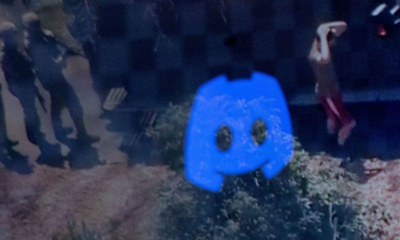 This photo illustration created on April 13, 2023 in Washington, DC, shows the Discord logo reflected in a screengrab of the suspect, national guardsman Jack Teixeira, being taken into custody by FBI agents in a forested area in North Dighton, in the northeastern state of Massachusetts. - FBI agents arrested a young national guardsman suspected of being behind a major leak of sensitive US government secrets -- including about the Ukraine war. US Attorney General Merrick Garland announced the arrest made "in connection with an investigation into alleged unauthorized removal, retention and transmission of classified national defense information." (Photo by MANDEL NGAN / AFP) (Photo by MANDEL NGAN/AFP via Getty Images)