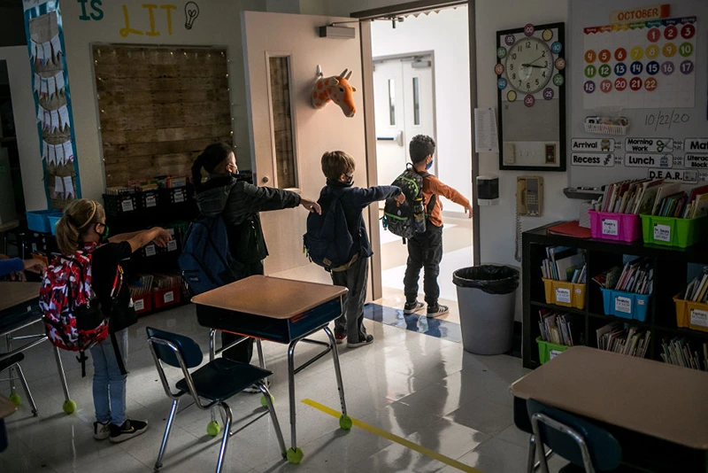 A kindergarten class socially distances while preparing to leave their classroom at Stark Elementary School on October 21, 2020 in Stamford, Connecticut. Stamford Public Schools is continuing the fall semester with a hybrid model of in-class and distance learning, occasionally quarantining individual classes when a student or faculty member tests positive for COVID-19. (Photo by John Moore/Getty Images)