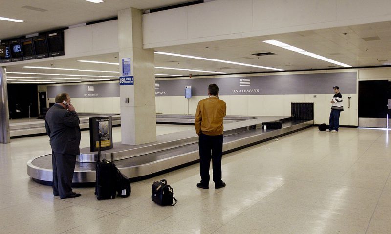 Passengers wait for their luggage at the U.S. Airways baggage carousel at O'Hare International Airport March 24, 2003 in Chicago, Illinois. Airline stocks dropped after Delta Airlines announced a reduction of services March 24, following similar cutbacks made recently by Continental, Northwest and United Airlines. (Photo by Scott Olson/Getty Images)