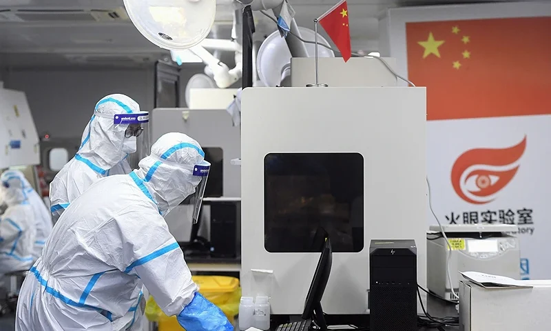 This photo taken on August 4, 2021 shows laboratory technicians wearing personal protective equipment (PPE) working on samples to be tested for the Covid-19 coronavirus at the Fire Eye laboratory, a Covid-19 testing facility, in Wuhan in China's central Hubei province. - China OUT (Photo by STR / AFP) / China OUT (Photo by STR/AFP via Getty Images)