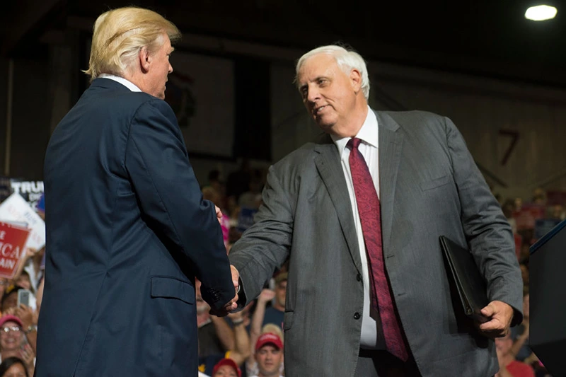 US President Donald Trump shakes hands with West Virginia Governor Jim Justice, who announced during the rally he would switch parties from Democrat to Republican, during a Make America Great Again Rally at Big Sandy Superstore Arena in Huntington, West Virginia, August 3, 2017. / AFP PHOTO / SAUL LOEB (Photo credit should read SAUL LOEB/AFP via Getty Images)