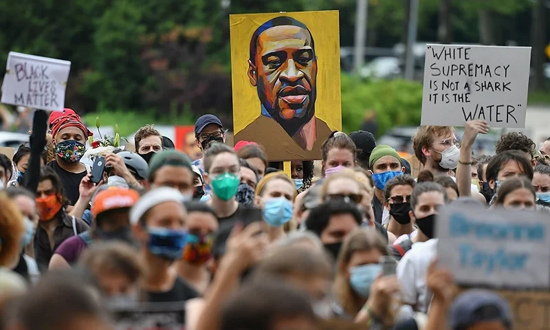 TOPSHOT - A protester holds up a portrait of George Floyd during a "Black Lives Matter" demonstration in front of the Brooklyn Library and Grand Army Plaza on June 5, 2020 in Brooklyn, New York, amid ongoing protests over Floyd's death in police custody. - The United States has seen more than a week of nationwide protests over the death in police custody of George Floyd, captured in a shocking video showing white officer Derek Chauvin kneeling on Floyd's neck for nearly nine minutes as he pleaded for his life. (Photo by Angela Weiss / AFP via Getty Images)