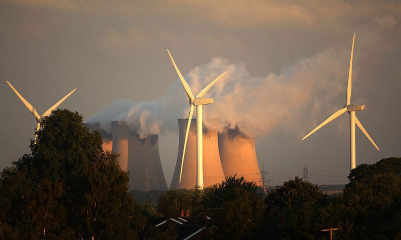 Recently installed wind turbines generate electricty in the shadow of Drax, Europe's biggest coal fired power station, on August 24, 2010 in Selby, England. The Rusholme wind farm will create 24 Mega Watts when fully operational in comparison to Drax which creates 3,960 Mega Watts. (Photo by Christopher Furlong/Getty Images)