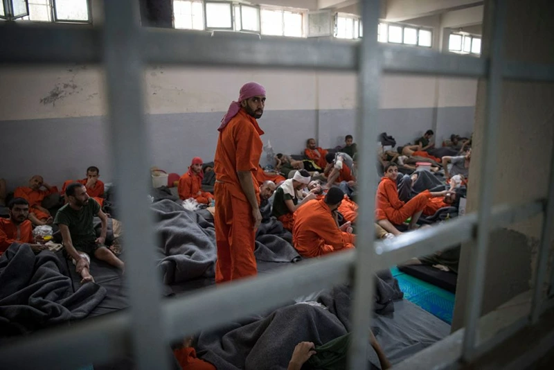 TOPSHOT - Men, accused of being affiliated with the Islamic State (IS) group, sit on the floor in a prison in the northeastern Syrian city of Hasakeh on October 26, 2019. - Kurdish sources say around 12,000 IS fighters including Syrians, Iraqis as well as foreigners from 54 countries are being held in Kurdish-run prisons in northern Syria. (Photo by FADEL SENNA / AFP) (Photo by FADEL SENNA/AFP via Getty Images)