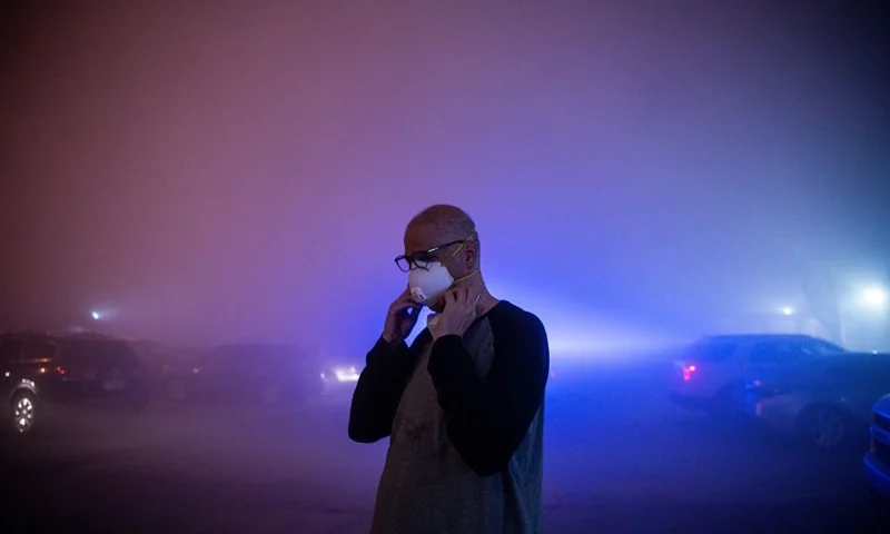A man stands in a cloud of dust after watching the rest of the Champlain South tower being demolished by a controlled explosion in Surfside, Florida, north of Miami Beach, late on July 4, 2021. - A controlled explosion brought down the unstable remains of the collapsed apartment block in Florida late on July 4 ahead of a threatening tropical storm as rescuers prepare to resume searching for victims. (Photo by CHANDAN KHANNA / AFP) (Photo by CHANDAN KHANNA/AFP via Getty Images)
