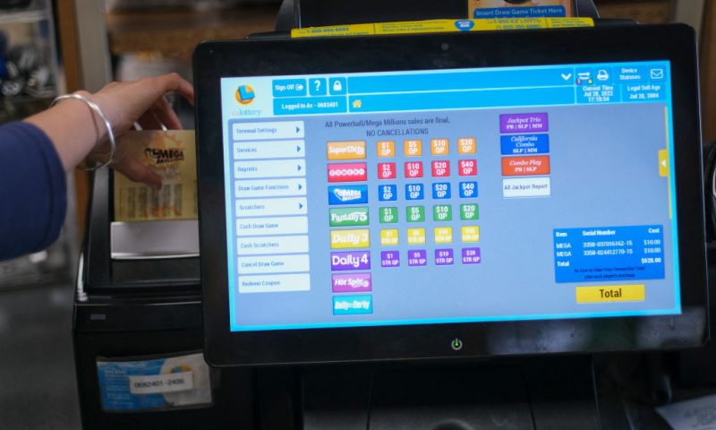 A cashier prints out a Mega Millions lottery ticket at a 7-Eleven convenience store in Chino Hills, California, July 28, 2022. - The odds of claiming this week's bonanza US lottery prize are less than one-in-300-million -- but one "lucky" convenience store outside Los Angeles is already counting its winnings. A sign above the counter of the otherwise unassuming shop in California's Chino Hills proclaims itself the "LUCKIEST 7-ELEVEN IN THE WORLD," six years after it sold a winning ticket for the largest jackpot in US lottery history. (Photo by RINGO CHIU / AFP) (Photo by RINGO CHIU/AFP via Getty Images)