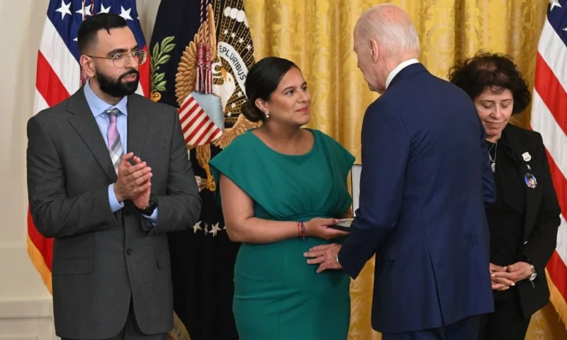 US President Joe Biden awards the Medal of Valor to (L-R) New York City Police Department (NYPD) Detective Sumit Sulan; Dominique Rivera, the wife of fallen NYPD Detective Jason Rivera; and Gabina Mora, the mother of fallen NYPD Detective Wilbert Mora, in the East Room of the White House in Washington, DC, on May 17, 2023. (Photo by SAUL LOEB / AFP) (Photo by SAUL LOEB/AFP via Getty Images)