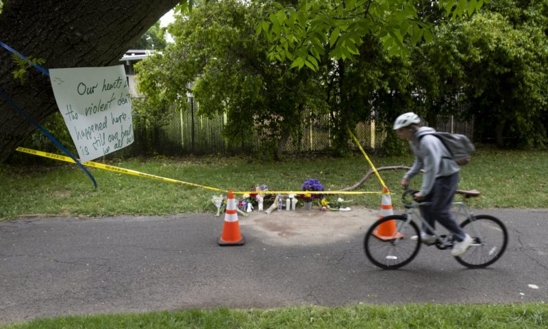 A cyclist rides past a memorial of flowers, Monday, May 1, 2023, marking the location that Karim Abou Najm, a graduating senior at UC Davis, was fatally stabbed in Sycamore Park in Davis, Calif. It was the city's second deadly stabbing at a park in three days. Residents of the Northern California university town are on edge after three people were stabbed within a week, including two fatally. (Paul Kitagaki Jr./The Sacramento Bee via AP)