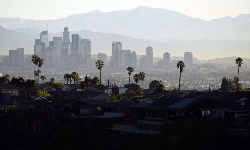 Palm trees stand above homes on the skyline in front of downtown Los Angeles after sunrise following heavy rain from winter storms, as seen from the Kenneth Hahn State Recreation Area, on March 2, 2023, in Los Angeles, California. (Photo by Patrick T. Fallon / AFP) (Photo by PATRICK T. FALLON/AFP via Getty Images)