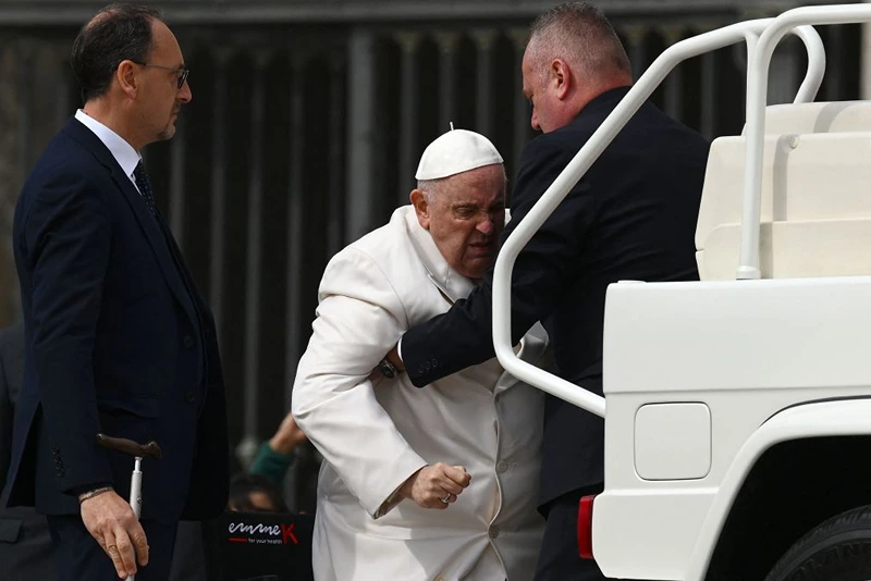 TOPSHOT - Pope Francis is helped get up the popemobile car as he leaves on March 29, 2023 at the end of the weekly general audience at St. Peter's square in The Vatican. - Pope Francis has been at the Gemelli Hospital in Rome since the afternoon of March 29, 2023 for some previously scheduled check-ups, the Holy See press director said. (Photo by Vincenzo PINTO / AFP) (Photo by VINCENZO PINTO/AFP via Getty Images)