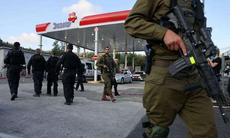 Israeli soldiers and police walk at a petrol station at the scene of an attack near the Jewish settlement of Eli in the north of the occupied West Bank on June 20, 2023. Four people were shot dead on June 20 near the settlement in the occupied West Bank, Israeli officials said, a day after an army raid left six Palestinians dead. (Photo by AHMAD GHARABLI / AFP) (Photo by AHMAD GHARABLI/AFP via Getty Images)