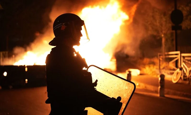 TOPSHOT - A firefighter looks on as vehicles burn following riots in Nanterre, west of Paris, on June 28, 2023, a day after a 17-year-old boy was shot in the chest by police at point-blank range in this western suburb of Paris. Violent protests broke out in France in the early hours of June 29, 2023, as anger grows over the police killing of a teenager, with security forces arresting 150 people in the chaos that saw balaclava-clad protesters burning cars and setting off fireworks. Nahel M., 17, was shot in the chest at point-blank range on June 27, 2023, morning in an incident that has reignited debate in France about police tactics long criticised by rights groups over the treatment of people in low-income suburbs, particularly ethnic minorities. (Photo by Zakaria ABDELKAFI / AFP) (Photo by ZAKARIA ABDELKAFI/AFP via Getty Images)