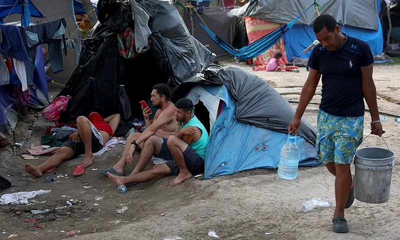 MATAMOROS, MEXICO - MAY 12: (L-R) Alfredo Gordillo, Luis Rodriguez, Johnny Durante, and Roberto Iglesias, originally from Venezuela, relax in a temporary encampment on the banks of the Rio Grande as they wait for permission to enter the United States on May 12, 2023 in Matamoros, Mexico. The number of immigrants reaching the border has surged with the end of the U.S. government's Covid-era Title 42 policy, which for the past three years has allowed for the quick expulsion of irregular migrants entering the country.(Photo by Joe Raedle/Getty Images)