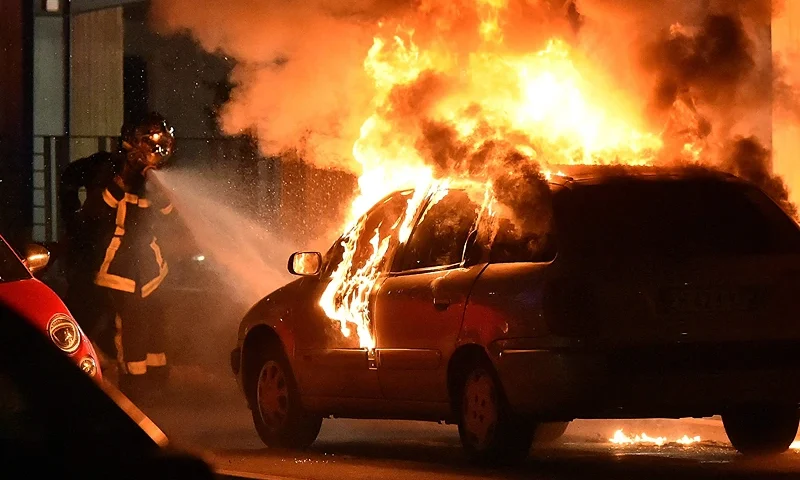 TOPSHOT - A firefighter sprays water to extinguish a burning car in the Mirail neighborhood in the French southwestern city of Toulouse, late on April 17, 2018. - Angry youths in a deprived area of the Toulouse have attacked police, torched cars and set fire to garbage during three nights of clashes. The rioting in the Mirail area of the southern city, a high-crime neighbourhood once home to several jihadists, was apparently sparked by the death of a local man in prison and an identity check by police on a veiled woman on April 15. (Photo by REMY GABALDA / AFP) (Photo by REMY GABALDA/AFP via Getty Images)