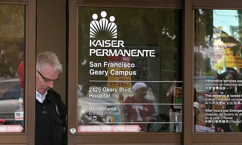 SAN FRANCISCO, CA - NOVEMBER 11: A security guard looks through a window as nurses strike outside of Kaiser Permanente hospital on November 11, 2014 in San Francisco, California. Nearly 18,000 Kaiser Permanente nurses in Northern California are staging a two-day strike amidst contract negotiations and to demand better working conditions, training and optimal safeguards for treating ebola. (Photo by Justin Sullivan/Getty Images)