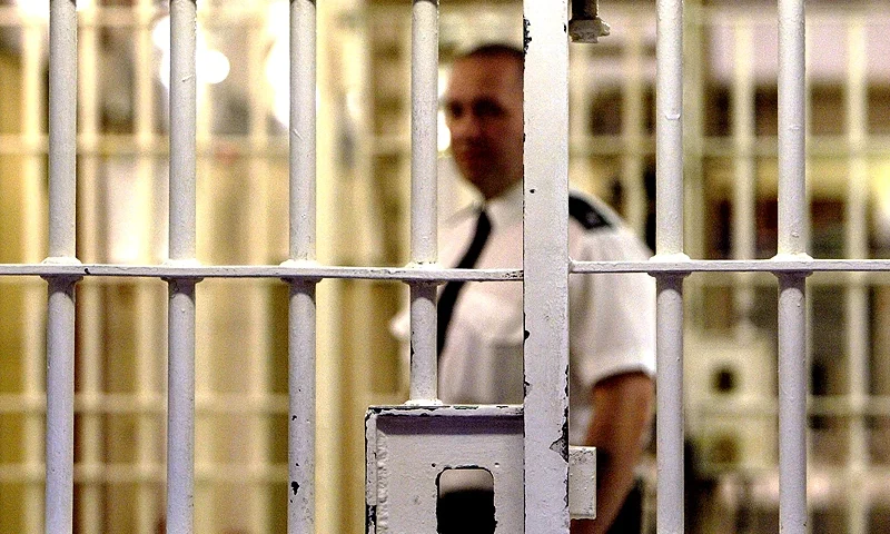 LONDON - MAY 19: (FILE PHOTO) A prison guard at HMP (Her Majesty's Prison) Pentonville stands behind a locked gate May 19, 2003 in London. A new report from the Prison Reform Trust (PRT) says overcrowding in Britain's prisons has been caused by tougher sentencing rather than an increase in crime. Since 1991, offenders of petty crimes are three times more likely to be imprisoned. (Photo by Ian Waldie/Getty Images)