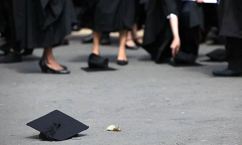 BIRMINGHAM, ENGLAND - JULY 14: Students pick up their mortarboards after the offical hat throwing photograph at the University of Birmingham on July 14, 2009 in Birmingham, England. Over 5000 graduates will be donning their robes this week to collect their degrees from The University of Birmingham. A recent survey suggested that there are 48 graduates competing for every job. (Photo by Christopher Furlong/Getty Images)
