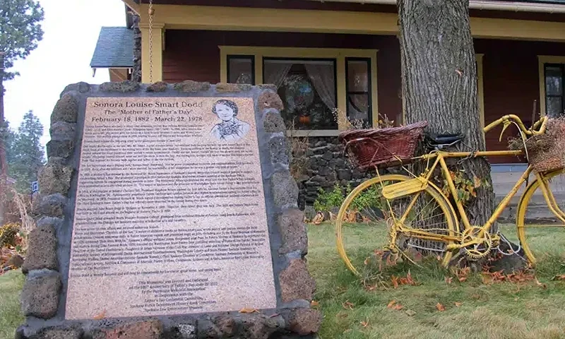 A sign stands on Nov. 21, 2014, outside the home where Sonora Smart Dodd lived in Spokane, Wash., in the early 20th century. The sign commemorates Dodd as the person who conceived the idea of Father's Day in 1909, the so-called ''Mother of Father's Day.'' The Craftsman-style house is privately owned and occupied, but the marker telling the story of the local connection to the holiday's history can be seen in the front yard. (Photo by AP News /Nicholas K. Geranios)
