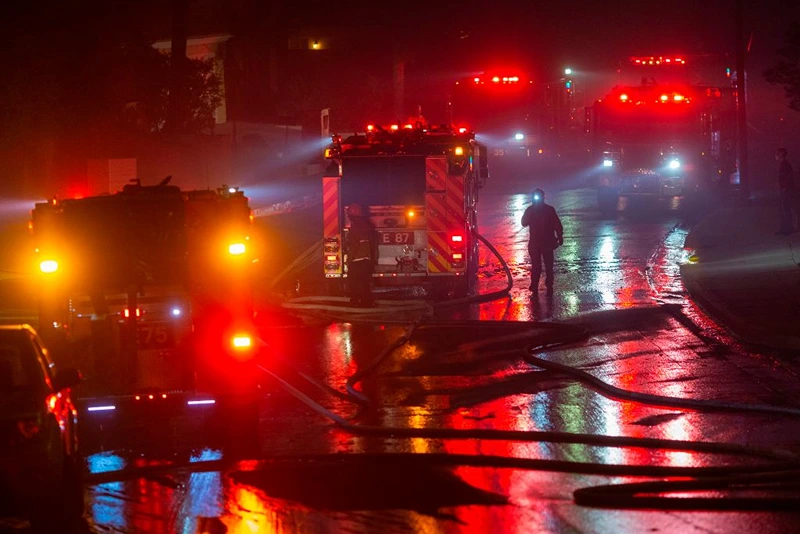 Firefighters work to save homes from the Saddleridge Fire in the Porter Ranch section of Los Angeles, California, on October 11, 2019. - The fire broke out late October 10 and has scorched some 4,600 acres (1,816 hectares), and forced mandatory evacuation orders for 12,700 homes. (Photo by DAVID MCNEW / AFP) (Photo by DAVID MCNEW/AFP via Getty Images)