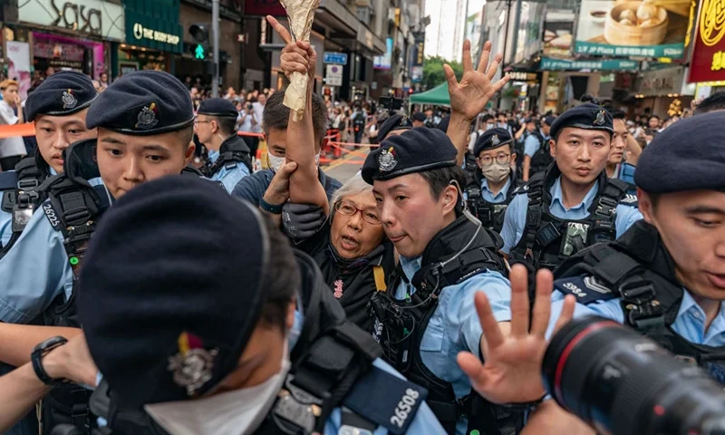 HONG KONG, CHINA - JUNE 04: Alexandra Wong, an activist known as Grandma Wong, is detained by police officers at Causeway Bay near Victoria Park on June 04, 2023 in Hong Kong, China. Victoria Park, where Hong Kong traditionally gathered annually to mourn the victims of China's Tiananmen Square crackdown in 1989, is currently hosting a three-day carnival co-organised by 26 pro-Beijing groups. (Photo by Anthony Kwan/Getty Images)