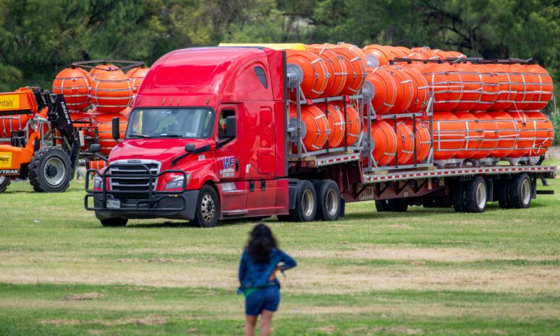 A woman surveys the preparation of a buoy barrier installation on July 07, 2023 in Eagle Pass, Texas. Texas has begun installing buoy barriers along portions of the Rio Grande river in an effort to deter illegal border crossings. (Photo by Brandon Bell/Getty Images)