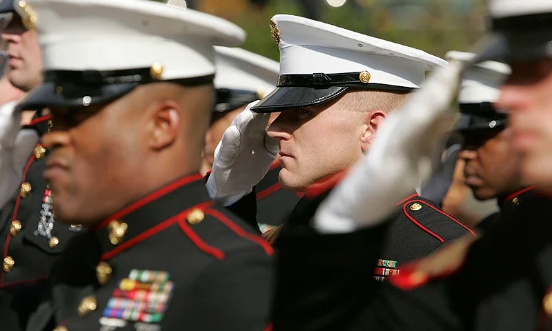 SAN FRANCISCO - NOVEMBER 10: Members of the U.S. Marine Corp honor guard salute during the singing of the National Anthem during the unveiling ceremony for the new "Distinguished Marines" commemorative stamps November 10, 2005 in San Francisco, California. The U.S. Postal Service issued a commemorative stamp series called "Distinguished Marines." on the 230th birthday of the U.S. Marine Corp. The four-stamp series features images of U.S. Marines Lewis B. Puller, Daniel J. Daly, John Basilone and John A. Lejeune. (Photo by Justin Sullivan/Getty Images)
