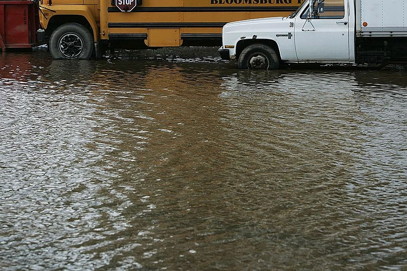 BLOONSBURG, PA - JUNE 29: A school bus and truck sit in standing water after flooding June 29, 2006 in Bloomsburg, Pennsylvania. Many homes in Bloomsburg had water lap into their first floor, filling their basements and ruining carpet and low-lying household items. (Photo by Chris Hondros/Getty Images)