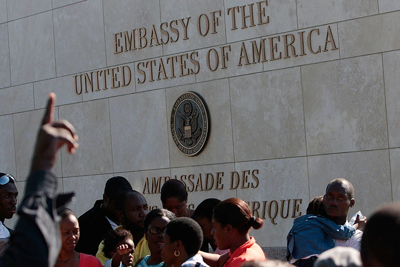 PORT-AU-PRINCE, HAITI - JANUARY 18: Hundreds of people, some with U.S. passports, stand in a long line outside of the American embassy as they try to leave the country January 18, 2010 in Port-au-Prince, Haiti. Untold thousands of Haitians are trying to leave their earthquake ravished country, but paths to leave are mired in bottlenecks and delays. Nearly a week after the earthquake devastated the impoverished island nation, relief supplies are in short supply and bodies continued to lie on the streets. (Photo by Chris Hondros/Getty Images)
