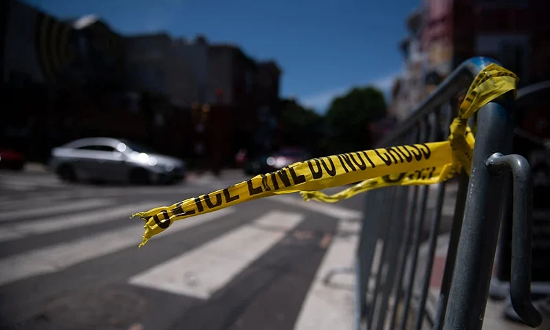 Police tape hangs from a barricade at the corner of South and 3rd Streets in Philadelphia, Pennsylvania, on June 5, 2022, the day after three people were killed and 11 others wounded by gunfire all within a few blocks. - Three people were killed and 11 others wounded late on June 4, 2022, in the US city of Philadelphia after multiple shooters opened fire into a crowd on a busy street, police said. (Photo by Kriston Jae Bethel / AFP) (Photo by KRISTON JAE BETHEL/AFP via Getty Images)
