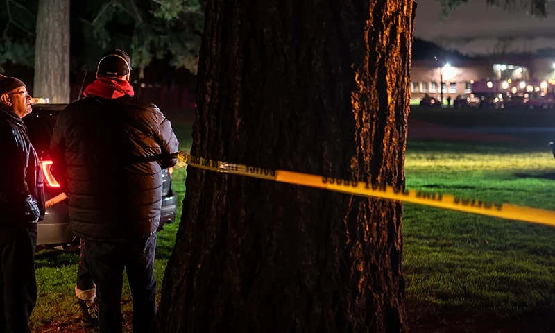 PORTLAND, OREGON - FEBRUARY 19: Neighbors watch as Portland police investigate a shooting that took place during a protest for Amir Locke, which officials said left one dead and five others injured, on February 19, 2022 in Portland, Oregon. Locke was shot and killed by police in Minneapolis, Minnesota during a no-knock raid earlier this month. (Photo by Nathan Howard/Getty Images)