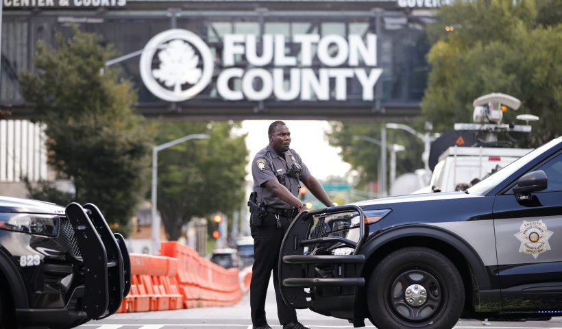A sheriff's deputy looks on near the Fulton County Courthouse, Monday, Aug. 14, 2023, in Atlanta. Court officials in Atlanta published a list of criminal charges against former President Donald Trump. But as a Fulton County grand jury began hearing from witnesses Monday, there was no public indication that Trump had been indicted in a long-running investigation of the 2020 presidential election. The list was later deleted. (AP Photo/Alex Slitz)