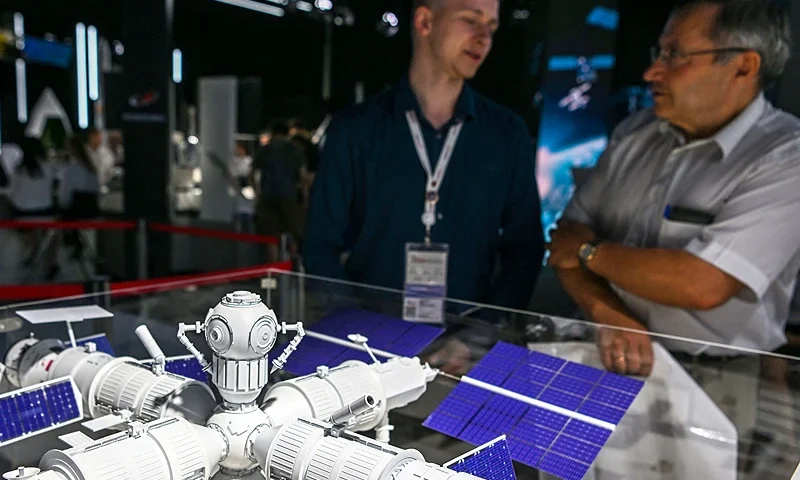 Visitors stand next to a mockup of a new Russian orbital space station, presented by Roscosmos State Space Corporation, during the Army-2022 International Military-Technical Forum at the Russian Armed Forces' Patriot Park in Kubinka, outside Moscow on August 16, 2022. (Photo by NATALIA KOLESNIKOVA / AFP) (Photo by NATALIA KOLESNIKOVA/AFP via Getty Images)