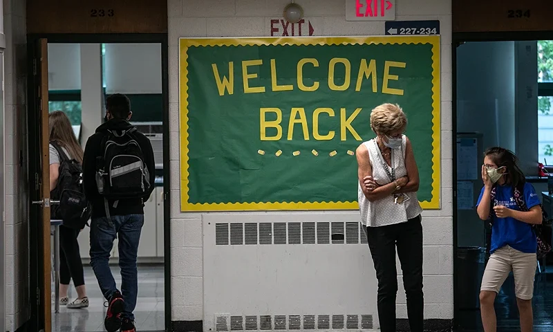 STAMFORD, CONNECTICUT - SEPTEMBER 14: A teacher speaks with a student between classes at Rippowam Middle School on September 14, 2020 in Stamford, Connecticut. Most students at the middle school are taking part in a hybrid model, where they attend in-school classes every other day and distance learn the rest. More than 20 percent of students in the Stamford Public Schools district are enrolled in the distance learning option only, due to coronavirus concerns. (Photo by John Moore/Getty Images)