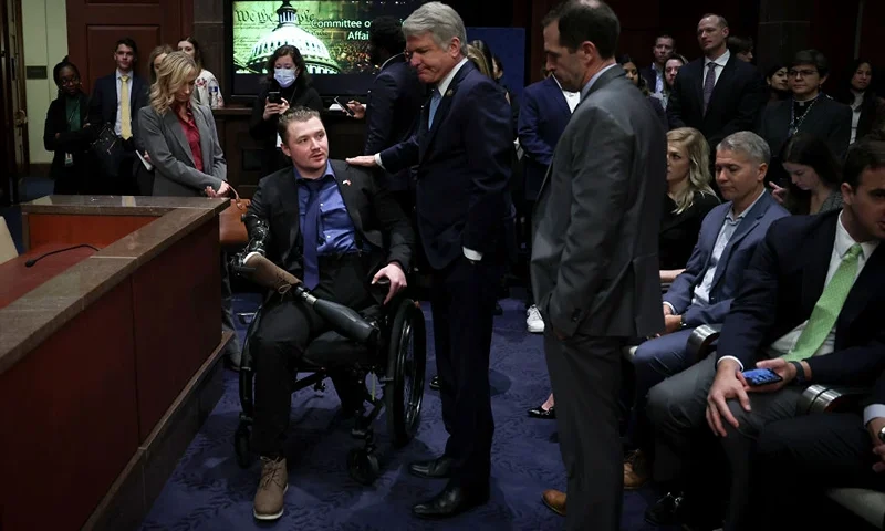 WASHINGTON, DC - MARCH 08: Committee Chair U.S. Rep. Michael McCaul (R-TX) (C) greets U.S. Marine Corps. Sergeant Tyler Vargas-Andrews (L) as he arrives to testify before the House Foreign Affairs Committee at the U.S. Capitol on March 08, 2023 in Washington, DC. The Committee held the hearing to examine the U.S. military withdrawal from Afghanistan and the emergency evacuation from Kabul. Vargas-Andrews was injured while defending an attack on Hamid Karzai International Airport while U.S. forces withdrew. (Photo by Win McNamee/Getty Images)