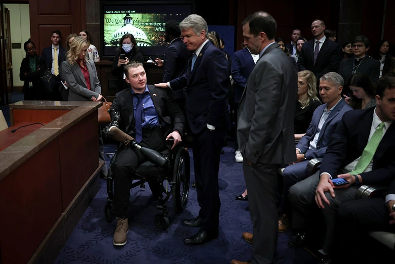WASHINGTON, DC - MARCH 08: Committee Chair U.S. Rep. Michael McCaul (R-TX) (C) greets U.S. Marine Corps. Sergeant Tyler Vargas-Andrews (L) as he arrives to testify before the House Foreign Affairs Committee at the U.S. Capitol on March 08, 2023 in Washington, DC. The Committee held the hearing to examine the U.S. military withdrawal from Afghanistan and the emergency evacuation from Kabul. Vargas-Andrews was injured while defending an attack on Hamid Karzai International Airport while U.S. forces withdrew. (Photo by Win McNamee/Getty Images)