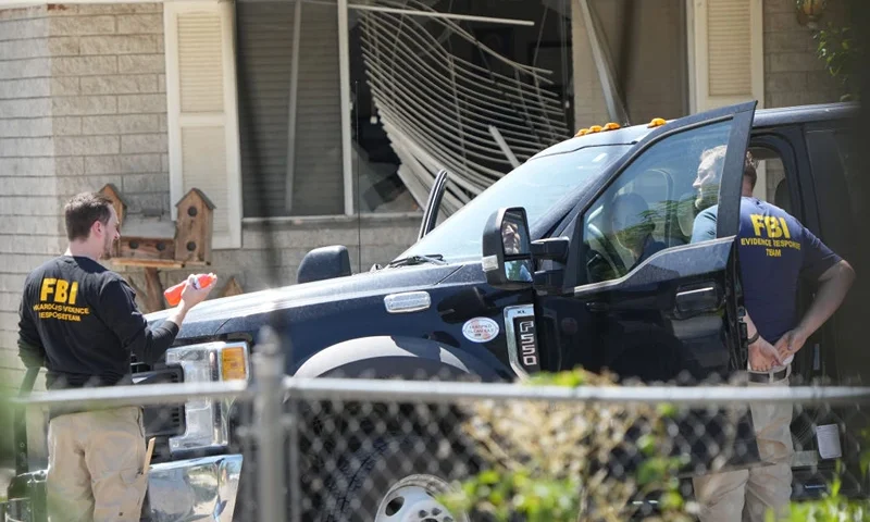 PROVO, UTAH - AUGUST 9: With a broken window in the background, FBI agents process the home of Craig Robertson who was shot and killed by the FBI in a raid on his home this morning on August 9, 2023 in Provo, Utah. The FBI was investigating alleged threats by Robertson to President Biden who is visiting Salt Lake City today and tomorrow. (Photo by George Frey/Getty Images)