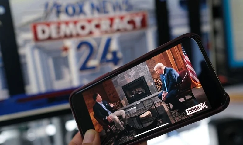 TOPSHOT - This illustration photo shows a preview of Tucker Carlson's interview of former US President Donald Trump scheduled to air on X (formerly Twitter) on the same night of the first Republican Presidential primary debate in Milwaukee, Wisconsin, on a smartphone ahead of the debate on August 23, 2023. (Photo by Chris DELMAS / AFP) (Photo by CHRIS DELMAS/AFP via Getty Images)