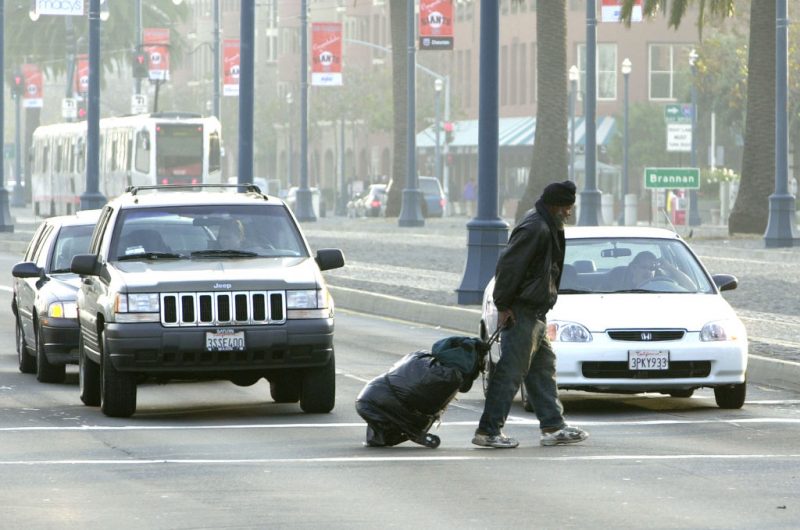 SAN FRANCISCO, CA - DECEMBER 5: Maceo Grigsby, a homeless man, pulls his belongings behind him as he crosses a street December 5, 2002 in San Francisco, California. San Francisco has attracted increasing numbers of homeless people in recent years. Official estimates tally homeless in the area to more than 12,000. Some people believe that the homeless are drawn to the area, in part, by welfare payments that are far too generous. (Photo by Justin Sullivan/Getty Images)