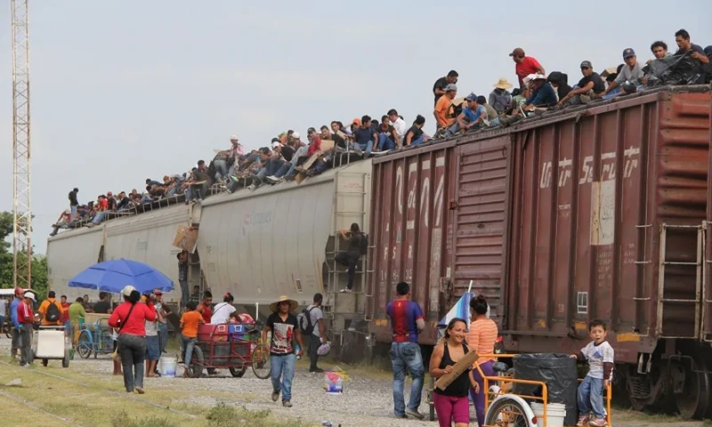TOPSHOT - Central American immigrant get on the so-called La Bestia (The Beast) cargo train, in an attempt to reach the Mexico-US border, in Arriaga, Chiapas state, Mexico on July 16, 2014. AFP PHOTO/ELIZABETH RUIZ (Photo by ELIZABETH RUIZ / AFP) (Photo by ELIZABETH RUIZ/AFP via Getty Images)